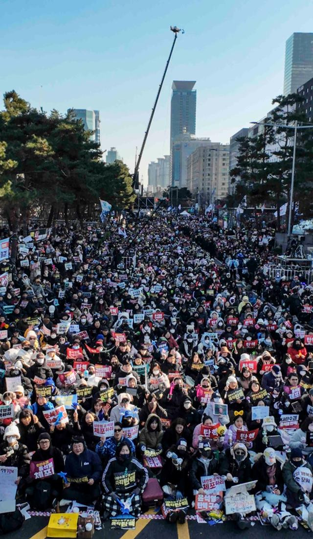 윤석열 대통령에 대한 탄핵소추안 표결을 앞둔 14일 서울 영등포구 국회의사당 앞에서 열린 윤석열 대통령 탄핵소추안 국회 통과 촉구 집회에서 시민들이 손팻말을 든 채 구호를 외치고 있다. 뉴시스