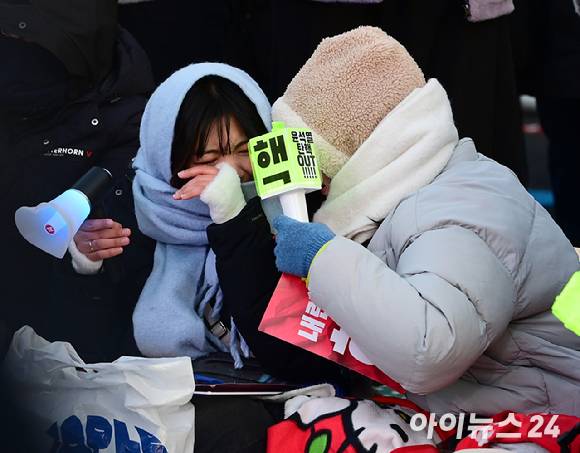 윤석열 대통령에 대한 탄핵소추안이 국회에서 통과된 14일 오후 서울 여의도 국회 앞에서 열린 윤 대통령 탄핵을 촉구하는 집회에 참석한 시민들이 눈물을 흘리고 있다. [사진=정소희 기자]