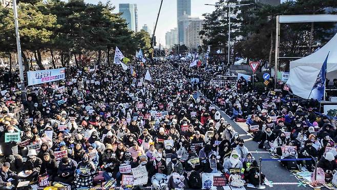 윤석열 대통령에 대한 탄핵 소추안 표결 앞두고 14일 서울 여의도 국회의사당 앞에서 열린 윤석열 대통령 탄핵소추안 국회 통과 촉구 집회에서 시민들이 손 피켓을 들고 구호를 외치고 있다. /사진=뉴시스