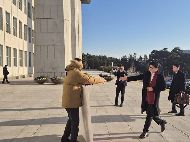 한동훈 국민의힘 대표가 14일 국회 본청에 출근하면서 탄핵 찬성 1인 시위 중인 김상욱 의원에게 악수를 청하고 있다. 국민의힘 제공