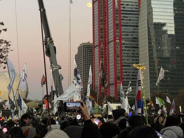 14일 윤석열 대통령에 대한 탄핵소추안이 가결된 이후 시민들이 보름달 아래에서 기뻐하고 있다. 문예빈 기자