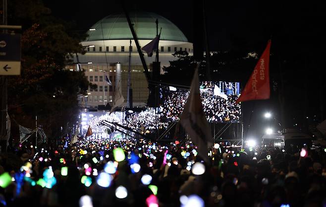 윤석열 대통령 탄핵소추안이 가결된 12월14일 서울 여의도 국회 앞에서 열린 촛불집회에 참석한 시민들이 응원봉과 촛불을 켠 채 환호하고 있다. ⓒ 연합뉴스