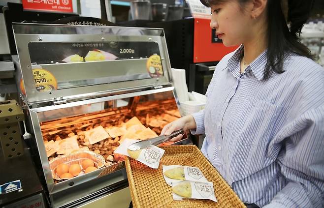 한 여성이 편의점에서 파는 붕어빵을 바구니에 넣고 있다. /GS리테일