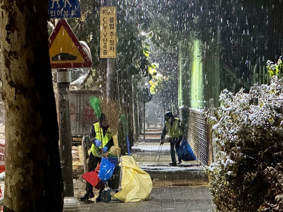 지난 11월 28일 새벽 경기도 고양시 덕양구의 한 거리에서 환경관리원(환경미화원)들이 눈이 내리는 가운데 미화 작업을 벌이고 있다.이들은 "몸을 숙이고 집게를 계속 쓰느라 허리와 팔꿈치가 쬐끔 아프네"라며 웃었다. 김홍준 기자