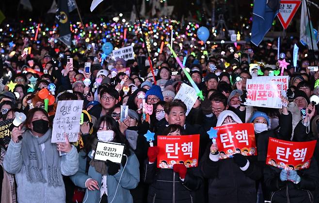 윤석열 대통령 탄핵소추안이 가결된 14일 오후 서울 여의도 국회 앞에서 열린 집회에 참석한 시민들이 환호하고 있다. 임세준 기자