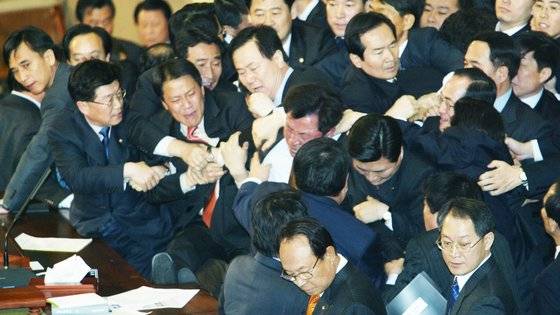 노무현 대통령 탄핵소추안이 처리되던 날 국회 본회의장의 모습. 의장석을 점거하고 있던 열린우리당 의원들이 국회 경호원과 야당 의원들에게 끌려 내려오고 있다. 중앙포토