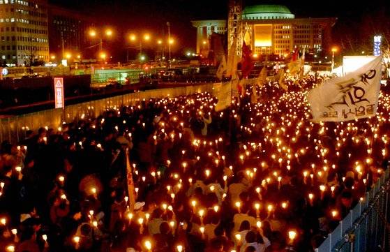국회에서 노무현 대통령의 탄핵소추안이 가결되자, 서울 여의도 국회 앞에 모인 시민들. '탄핵 무효' 구호를 외치며 촛불 시위를 벌이고 있다. 중앙포토