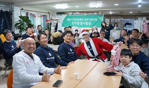 서울 강동구 오륜레인보우지역아동센터에서 퀄컴코리아 임직원들이 초록우산과 함께 교육 봉사활동을 진행하고 기념촬영하고 있다. [사진=퀄]