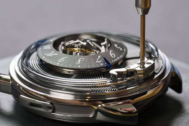 해머가 다이얼 가장자리를 감싼 공을 때려 소리를 내는 미니트리미터 시계 제작 과정. 사진의 모델을 올해 발표한 '아쏘 뒥 아뜰레' 모델이다. 사진 에르메스