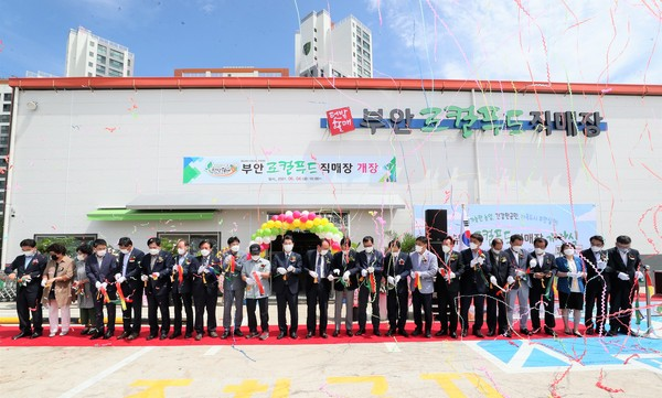 ▲부안로컬푸드직매장 ‘텃밭할매’의 개장 1주년 상생행사장에서 참석자들이 테이프를 자르고 있다.ⓒ