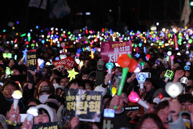 지난 14일 내란죄 피의자 윤석열 대통령에 대해 국회에서 탄핵소추안이 가결된 뒤 집회에 참가한 청년 여성들이 윤석열 탄핵과 즉각 체포를 요구하며 응원봉을 흔들고 있다. 김태형 기자 xogud555@hani.co.kr