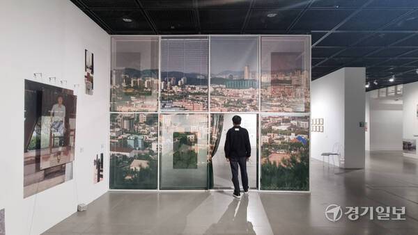 수원시립미술관 관계자가 수원의 옛 풍경을 담아낸 김소라 작가의 작품 앞에 서 있다. 이나경기자