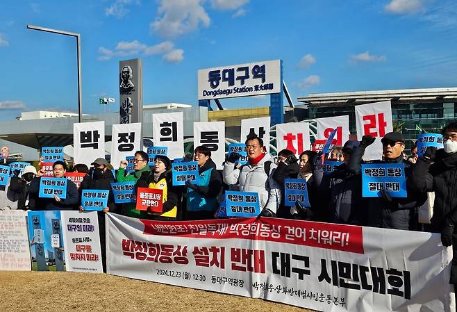 (대구=뉴스1) 남승렬 기자 = 범야권 시민단체 등으로 구성된 '박정희우상화사업반대범시민운동본부'가 23일 오후 대구 동구 신천동 동대구역 광장에서 '박정희 동상 설치 반대 대구 시민대회'를 열고 '박정희 동상' 철거를 촉구하고 있다. 2024.12.23/뉴스1