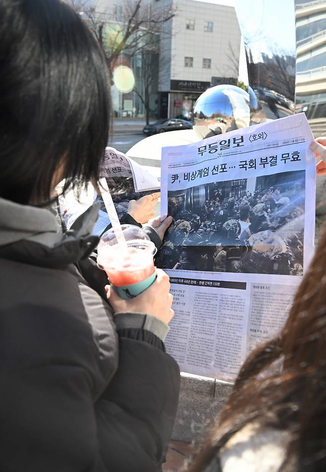 12월4일자 <무등일보> 호외를 읽고 있는 광주의 한 시민. ⓒ<무등일보> 제공