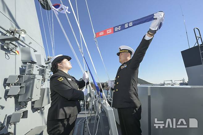 [창원=뉴시스] 차용현 기자 = 충남함 장병들이 24일 진해군항에서 개최된 취역식에서 충남함 마스트에 취역기를 게양하고 있다. 2024.12.24. (사진=해군 제공) photo@newsis.com