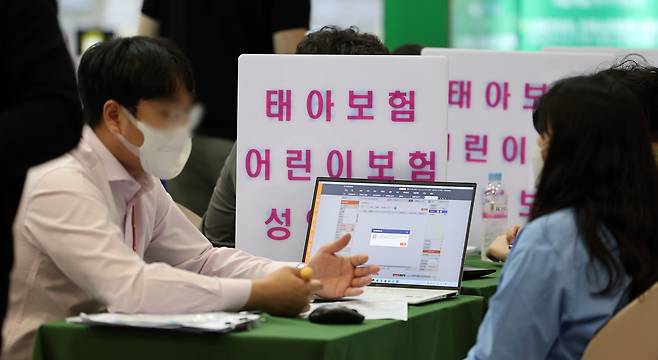 지난 5월 경기 고양시에서 열린 '2024 코베 베이비페어·유아교육전'을 찾는 관람객이 태아보험 상담을 받고 있다. /뉴스1