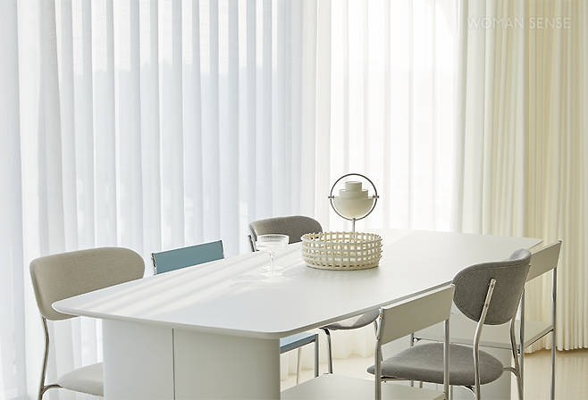 유연한 곡선의 세라믹 상판을 사용한 사보 세라믹 테이블은 세라믹과 자작나무를 결합했다. 튼튼해 보이는 다리는 디자인까지 수려하다. 의자는 두 종류를 섞어 배치했는데, 반듯한 느낌의 라토 체어와 곡선의 아름다움을 살린 볼리니 체어가 조화롭다. 테이블과 의자는 모두 플랫포인트. 형상 기억 공정을 거쳐 완벽한 나비 주름을 구현한 전동 커튼은 덱스터. 테이블 위 세라믹 센터피스는 전통적인 바구니 짜기 기술을 도자기에 접목해 핸드메이드로 제작한 펌리빙 트레이, 조명은 원하는 각도로 회전시킬 수 있는 구비 포터블 램프로 모두 에잇컬러스에서 구입 가능하다.