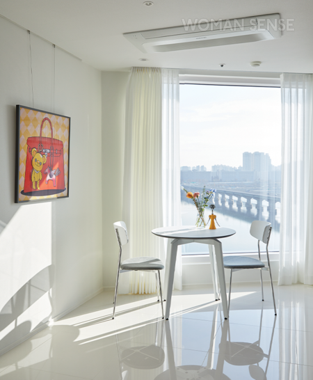 아침 식사할 때 주로 앉는 원형 테이블은 디엘로의 바이런 테이블&체어, 공간에 따스함을 주는 전동 커튼은 덱스터, 그림은 김미네 작가의 작품 ‘NOBODY with Hermès’.