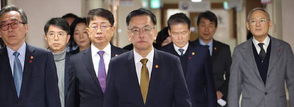 최상목 경제부총리 겸 기획재정부 장관(가운데)과 국무위원들이 27일 서울 종로구 정부서울청사에서 한덕수 대통령 권한대행 국무총리 탄핵에 대한 입장을 발표를 위해 브리핑룸으로 향하고 있다. 2024.12.27 [사진=연합뉴스]
