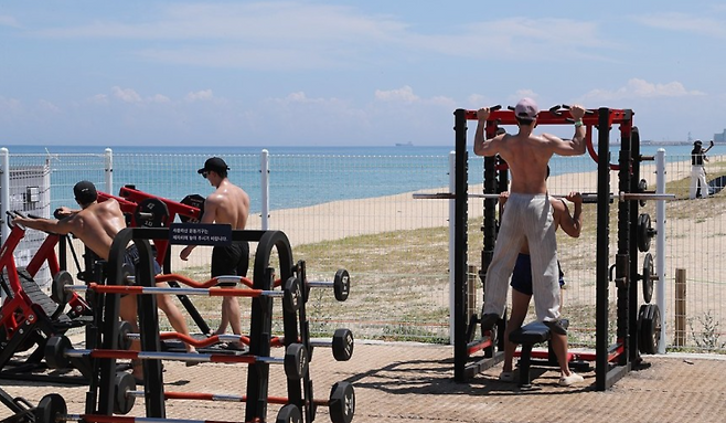 강원 강릉시 강문해변 머슬비치에서 피서객들이 운동하고 있다. 연합뉴스