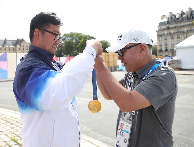 정의선 현대자동차그룹 회장에게 파리올림픽 남자양궁 3관왕 김우진이 금메달을 걸어주고 있다. 연합뉴스