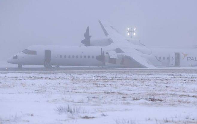 에어캐나다 익스프레스 2259편 여객기가 28일(현지시간) 캐나다 노바스코샤주 핼리팩스 스탠필드 국제공항에 멈춰 있다. 이 항공기는 랜딩기어 이상으로 날개가 땅에 닿은 채 동체 착륙으로 멈춰섰다. ⓒ AP/연합뉴스