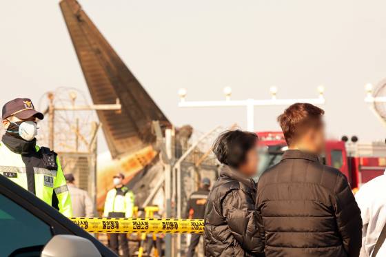 무안 제주항공 참사 수습이 이뤄지는 현장에서 실종자 가족이 상황을 지켜보고 있다. 뉴스1