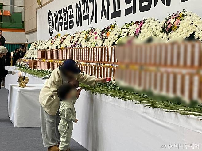 전남 무안군에 거주하는 박모씨(28)는 4살 아들과 함께 합동분향소를 찾았다. 박씨는 "가장 어린 희생자가 2021년생이라고 하는데 저희 아이와 나이가 같아 더 마음이 쓰였다"며 "아이에게 저기 친구 있다고 자동차 모형 장난감 줘도 되냐고 물어보니 좋다고 해서 국화꽃 대신 올려놓고 왔다"고 말했다. 조문을 하는 박씨와 박씨 아들의 모습./사진=김선아 기자