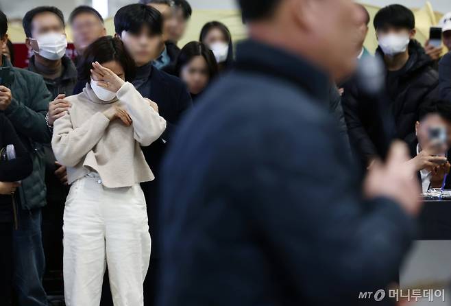 30일 오후 전남 무안국제공항에서 한 유가족이 제주항공 참사와 관련한 유가족협의회 대표의 성명서를 듣던 도중 눈물을 흘리고 있다./사진=뉴시스