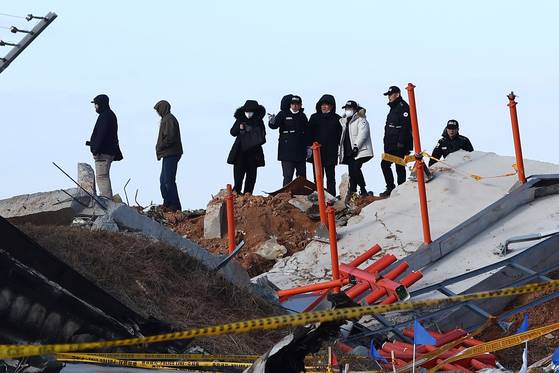 31일 오후 전남 무안국제공항 제주항공 여객기 참사 현장에서 미국 연방항공청, 교통안전위원회, 보잉 등 한미합동조사 관계자들이 사고 여객기와 충돌로 부서진 방위각 시설(로컬라이저) 등을 조사하고 있다. 장진영 기자