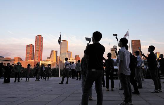 YouTubers are filming with their phones in Yeouido, western Seoul, on Aug. 31, 2023. [YONHAP]