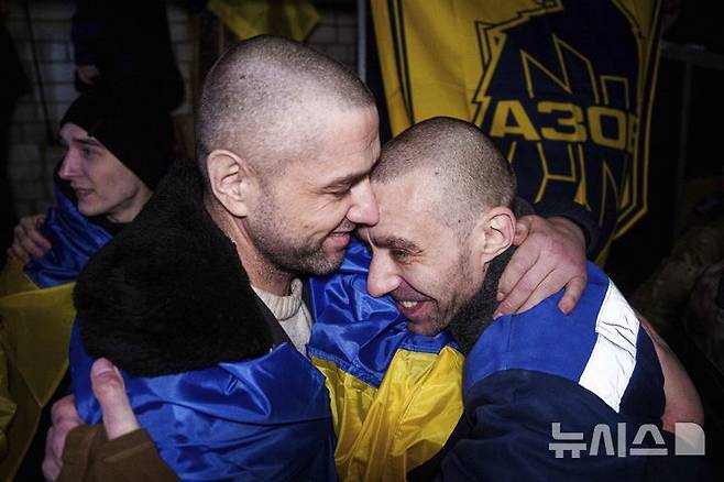 [우크라이나=AP/뉴시스] 30일(현지시각) 러시아와 우크라이나 간의 포로 교환으로 풀려난 우크라이나 아조우 여단 소속 군인들이 서로를 끌어안고 있다. 새해를 앞두고 러시아와 우크라이나 전쟁 포로 300여 명이 아랍에미리트(UAE)의 중재로 이날 포로 교환을 통해 귀환했다. 2024.12.31.