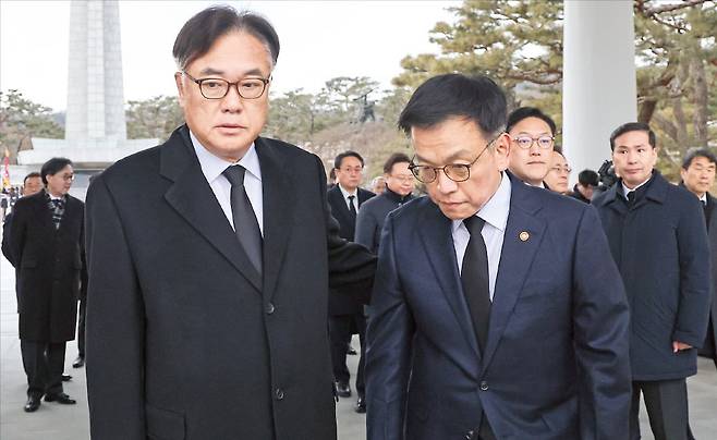 < 여권내 균열 >  최상목 대통령 권한대행(오른쪽)이 1일 서울 동작동 국립서울현충원 현충탑에서 신년 참배를 마친 뒤 정진석 대통령 비서실장과 다른 곳을 응시하며 스쳐 지나가고 있다.  /김범준 기자