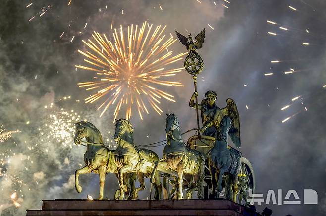 [베를린=AP/뉴시스] 1일(현지시각) 독일 베를린 브란덴부르크문의 4두 2륜 전차 '콰드리가' 상공에서 새해 축하 불꽃놀이가 펼쳐지고 있다. 2025.01.01.