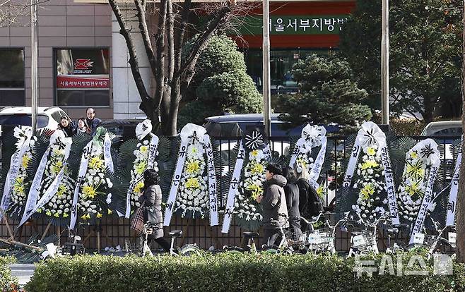 [서울=뉴시스] 김근수 기자 = 윤석열 대통령에 대한 체포영장을 발부한 서울서부지방법원 앞에 법원을 비난하는 근조화환이 설치된 2일 서울 마포구 서울서부지방법원 앞으로 한 시민들이 지나가고 있다. 2025.01.02. ks@newsis.com