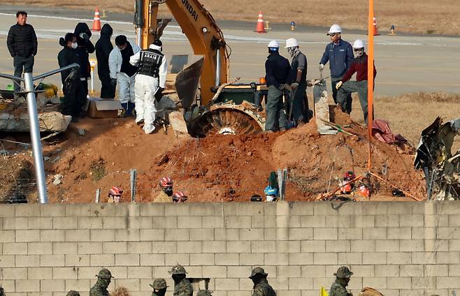 2일 오후 전남 무안군 무안국제공항 제주항공 참사 현장에서 합동조사단 관계자들이 로컬라이저 둔덕에 파묻힌 엔진을 꺼내는 작업을 하고 있다./ 연합뉴스