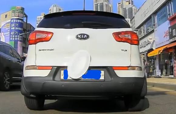 도로를 달리던 차량의 번호판에 버려진 일회용 접시가 붙어 번호를 가렸다. [사진=한문철 TV 유튜브]