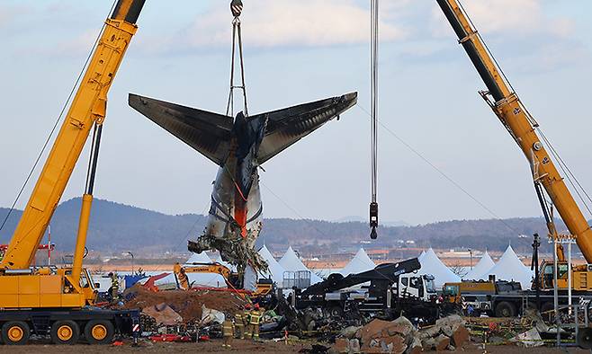 제주항공 여객기 참사 6일째인 3일 전남 무안국제공항 사고 현장에서 소방당국 관계자들이 꼬리날개 부분을 크레인으로 인양하고 있다. 연합뉴스