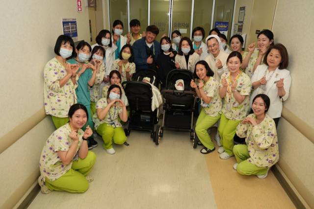 '오둥이' 아빠 김준영씨 부부(가운데)가 3일 둘째 새찬이, 셋째 새강이의 퇴원 전 서울성모병원 의료진과 기념사진을 찍었다. 사진 제공=서울성모병원