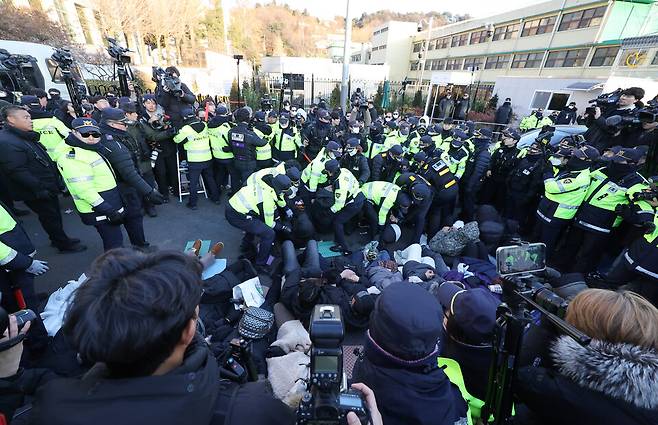 윤석열 대통령에 대한 체포영장 발부 사흘째인 1월2일 서울 용산구 한남동 대통령 관저 정문 앞 도로에 누워있는 지지자들을 경찰들이 해산시키려 하고 있다. ⓒ 연합뉴스