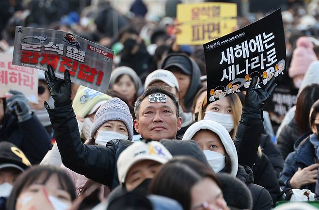 4일 오후 서울 종로구 광화문광장 인근에서 윤석열 즉각퇴진·사회대개혁 비상행동이 5차 시민대행진을 열어 참석자들이 손팻말을 들어보이고 있다. 신소영 기자 viator@hani.co.kr