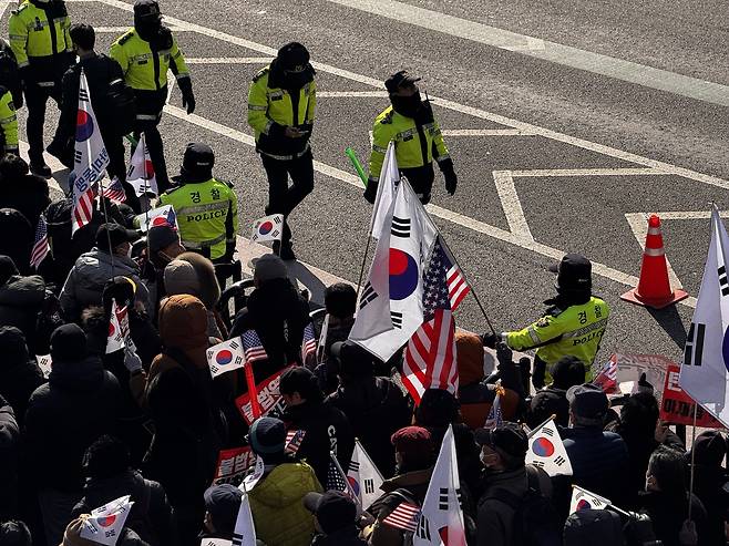 Demonstrators rally in support of impeached President Yoon Suk Yeol, waving South Korean and American flags as symbols of anti-communism and the Korea-US alliance, Friday morning in Seoul. (Moon Joon-hyun/The Korea Herald)