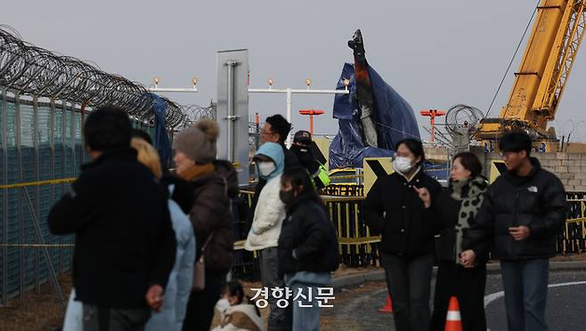 시민들이 무안국제공항 사고현장 인근에서 희생자들을 추모하고 있다.