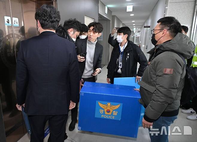 [무안=뉴시스] 김선웅 기자 = 2일 전남 무안군 무안국제공항 운영부 사무실에서 압수수색을 마친 경찰 관계자가 박스를 들고 나서고 있다. (공동취재) 2025.01.02. photo@newsis.com