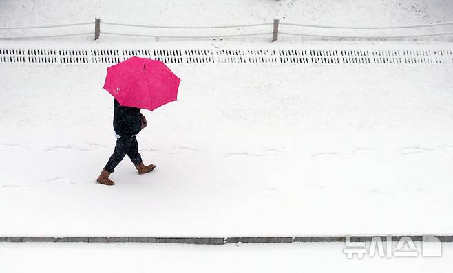 [서울=뉴시스] 조성우 기자 = 동남권을 제외한 서울 일부 지역에 대설주의보가 내려진 5일 오전 서울 여의도 국회에서 한 시민이 우산을 쓰고 걸어가고 있다. 2025.01.05. xconfind@newsis.com