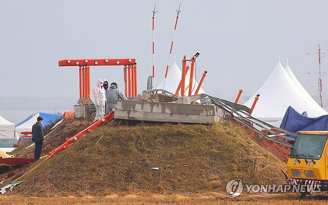 방위각시설 살피는 관계자들 (무안=연합뉴스) 김도훈 기자 = 5일 오전 전남 무안국제공항 제주항공 여객기 사고 현장에서 관계자들이 방위각시설(로컬라이저)을 살피고 있다. 2025.1.5 superdoo82@yna.co.kr