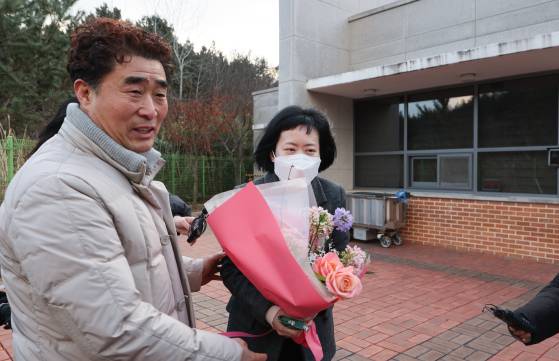 사건 발생 24년 만에 재심에서 무죄를 선고받은 김신혜 씨가 6일 전남 장흥군 용산면 장흥교도소에서 석방돼 '낙동강살인사건'으로 억울한 옥살이를 했던 장동익씨로부터 꽃다발을 받고 있다. 연합뉴스