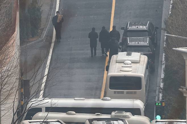 고위공직자범죄수사처가 발부받은 내란죄 피의자 윤석열 대통령에 대한 체포영장 집행 시한 마지막날인 6일 오전 서울 용산구 대통령 관저 들머리에서 관계자들이 서류봉투를 들고 걸어가고 있다. 김영원 기자 forever@hani.co.kr