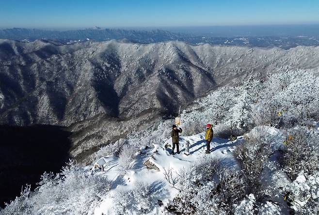 눈이 소복하게 덮은 백덕산 정상부. 뒤로 사자산 능선이 감싸고, 멀리 치악산이 펼쳐진다.