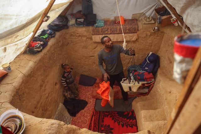 이스라엘군의 가자지구 공격이 계속되고 있는 가운데 8일 가자지구 데이르알발라 난민촌에서 한 팔레스타인 피란가족이 추위와 이스라엘의 공격으로부터 가족을 보호하기 위해 텐트 아래에 참호를 만들고 생활하고 있다. 데이르알발라=AFP 연합뉴스